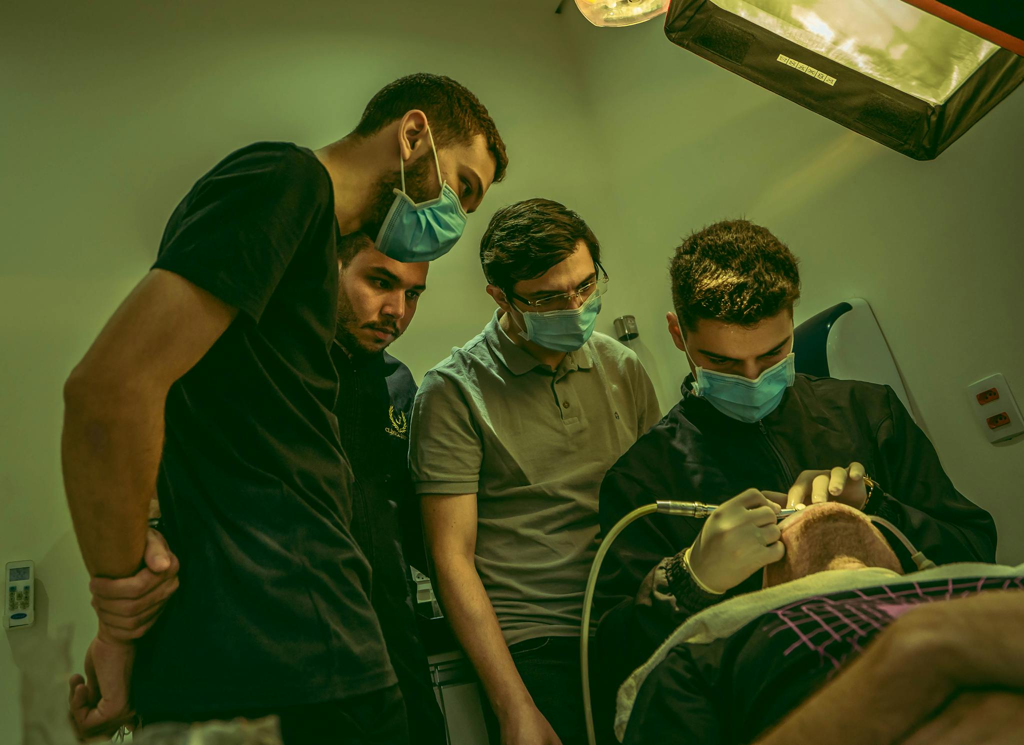 Dentists and team performing a procedure in a dental clinic, focused and engaged.